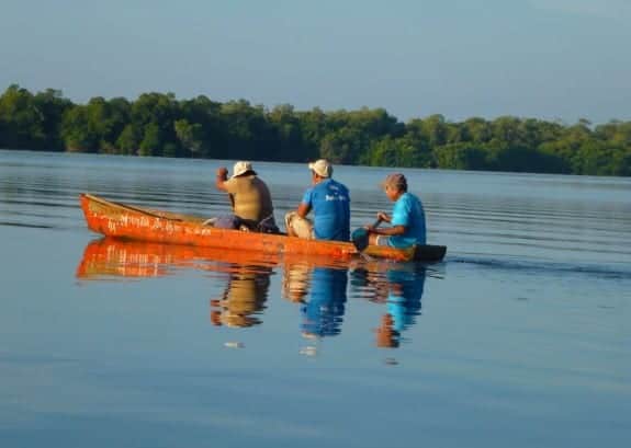 Fishermen on a canoe at Manialtepec Lagoon in Puerto Escondido by day 