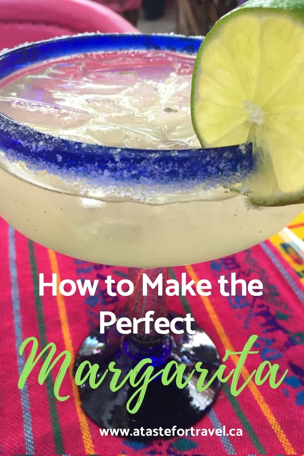 A margarita cocktail with a lime garnish on a Mexican tapestry with text overlay How to Make the Perfect Margarita. .
