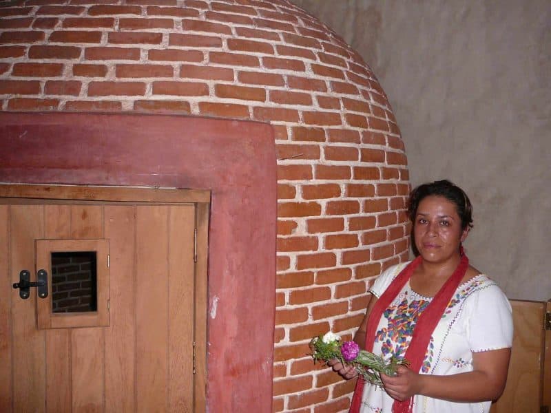 Female shaman holding a corona of flowers outside a temascal in Oaxaca Mexico. 