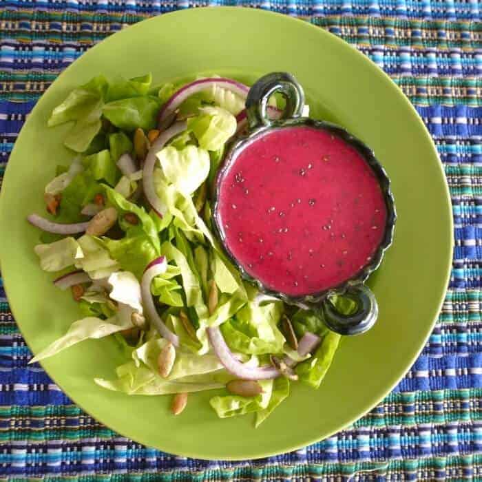 Healthy prickly pear and chia salad dressing with green lettuce on a lime green plate. 