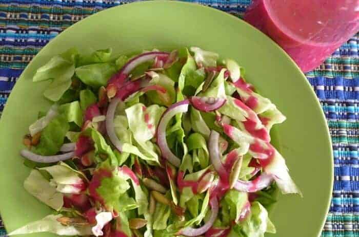 Prickly pear and chia salad dressing drizzled on fresh greens 