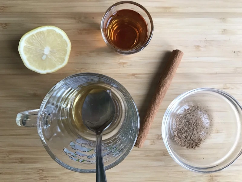 Ingredients for hot bourbon toddy including bourbon, lemon nutmeg and honey. 