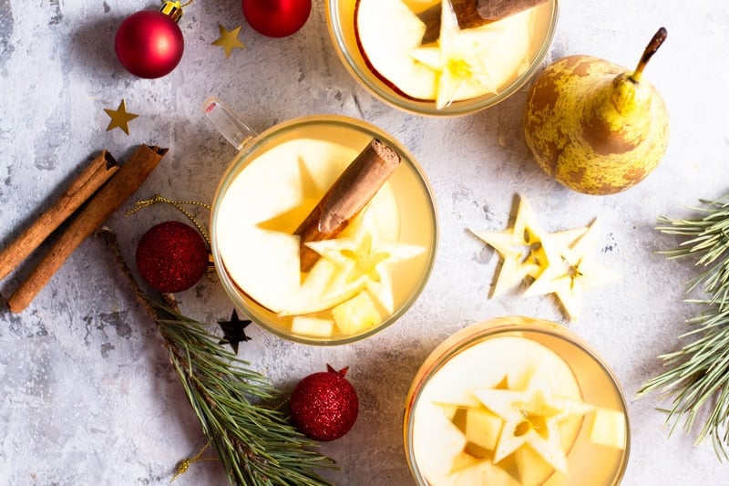 Ponche de Frutas in festive glasses with Christmas and New Year's Eve greenery. 