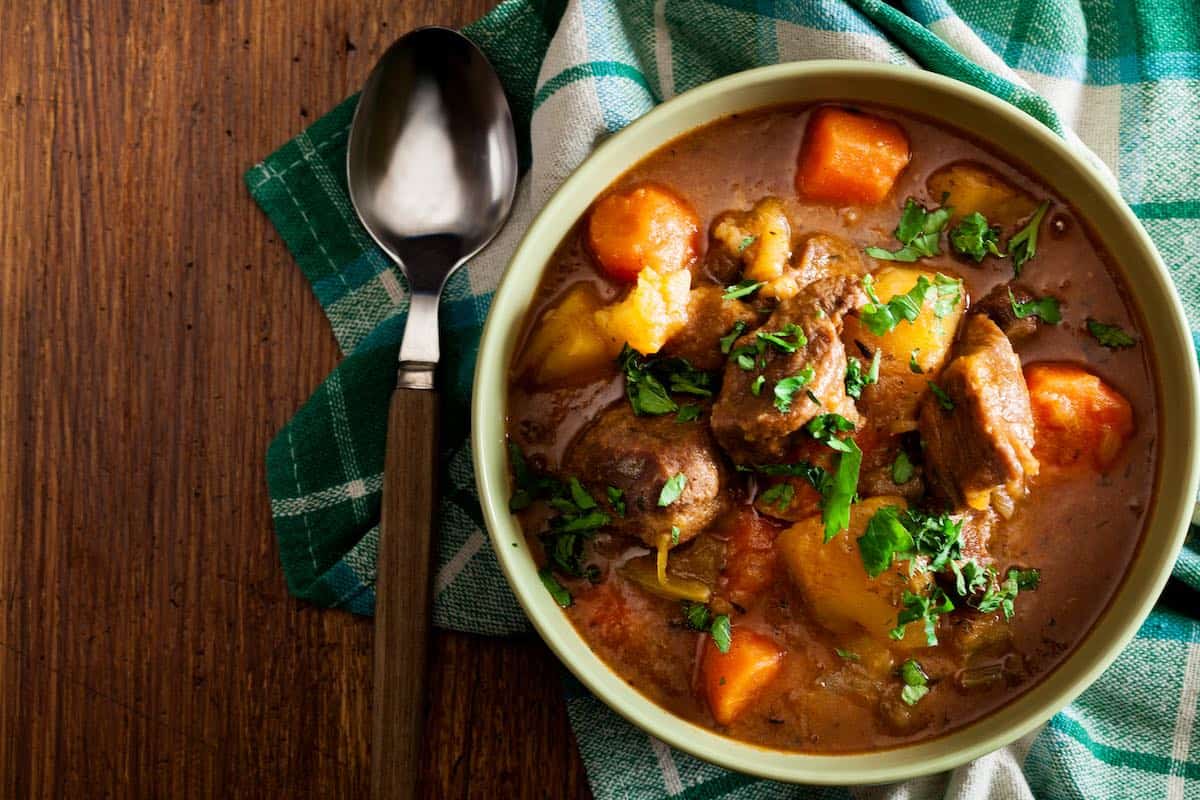 A bowl of hearty Irish stew made with beef, potatoes, carrots and herbs.