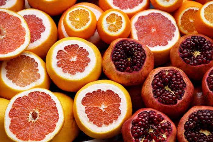 Sliced oranges and pomegranates. Photo by Israel Egío on Unsplash