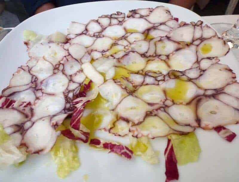 Carpaccio di Pulpo on a white plate at Osteria der Belli in Rome.