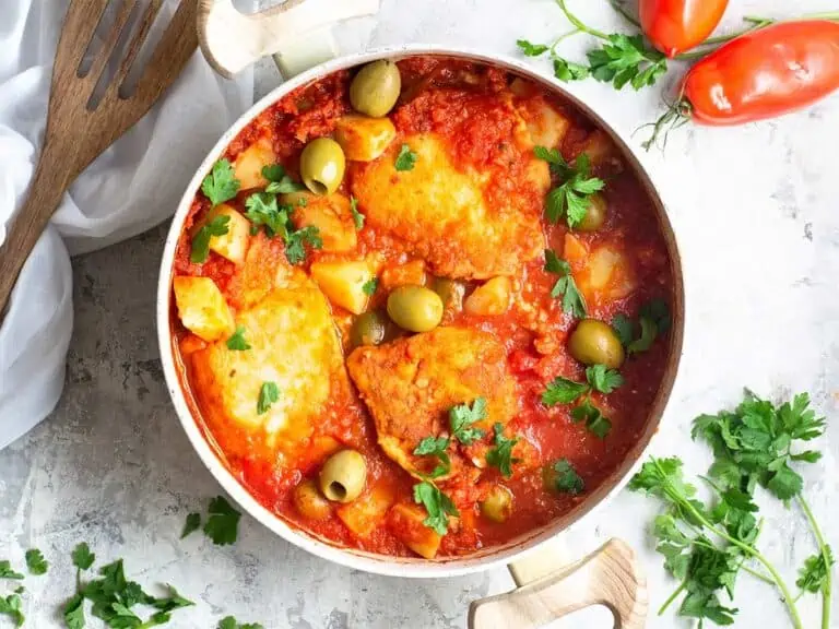 Bowl of bacalao finished and garnished with parsley.