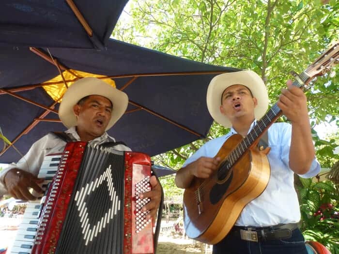 Two men with guitars wearing cowboys hats and singing in Mexico. 