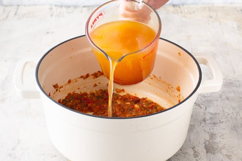 Add broth to sofrito in tapado recipe