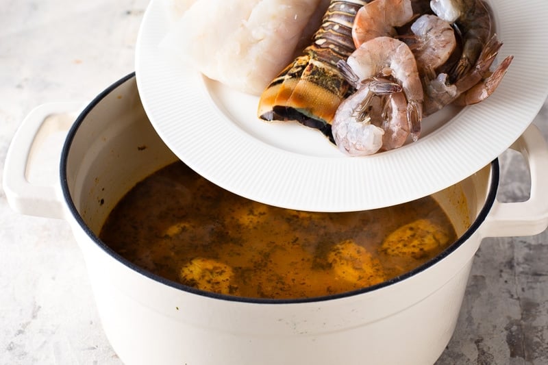 Adding seafood to tapado Guatemalan seafood soup