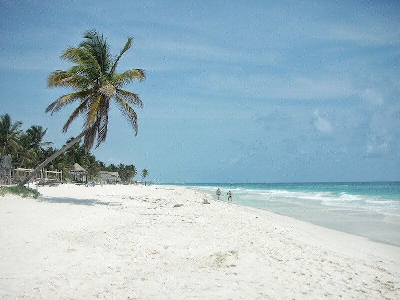 View of the white sand beach at Azucar Tulum. 