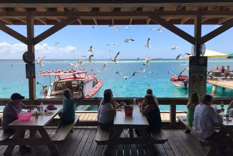 People sitting on the outdoor deck at Zeerovers Aruba.