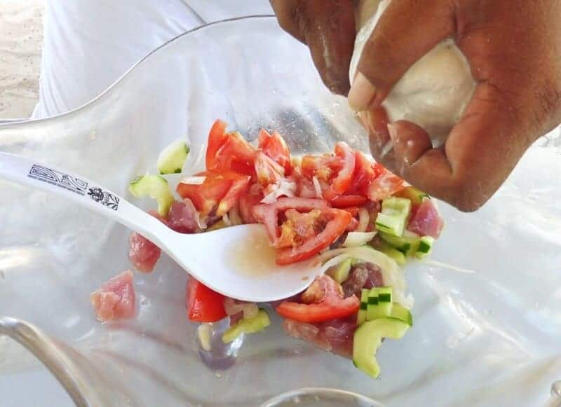 Chef squeezing coconut milk to make Poisson Cru Tahitienne.