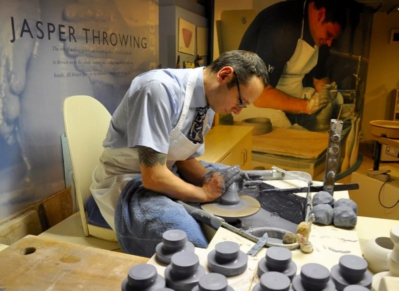Artisan shaping a piece of pottery while Jasperware throwing at Wedgwood World.