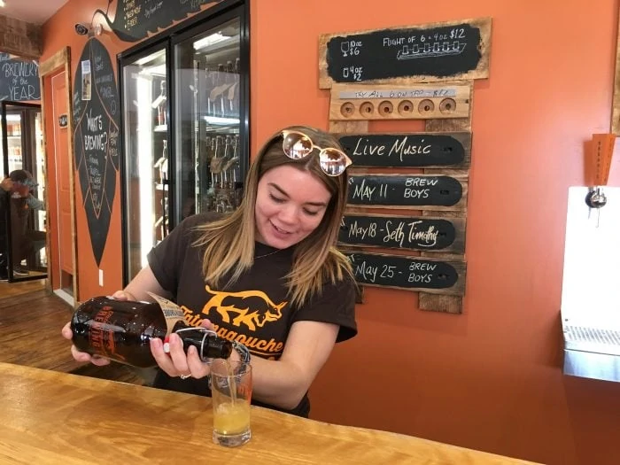 Young woman pouring a beer sample at Tatamagouche Brewery. Credit Kathy and Danny Gillis