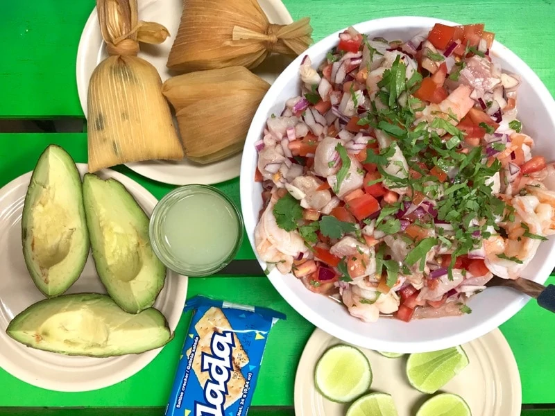 Ceviche Mixto Guatemalteco served with avocado, lime and crackers. 