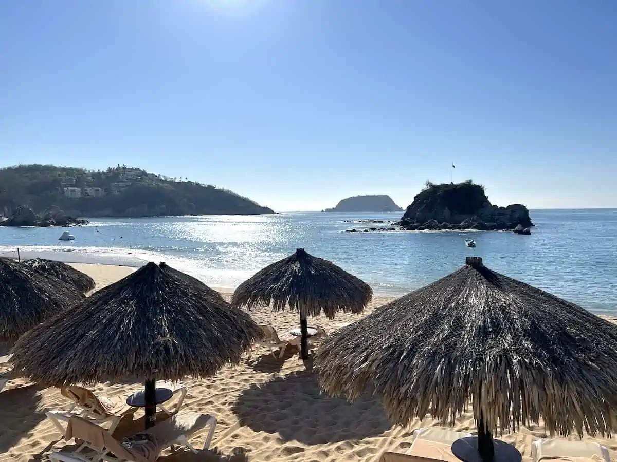 Loungers and beach palapas at Barcelo Resort in Huatulco Mexico.