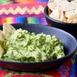 Guatemalan Guacamole in an earthen bowl on a Mayan weaving.