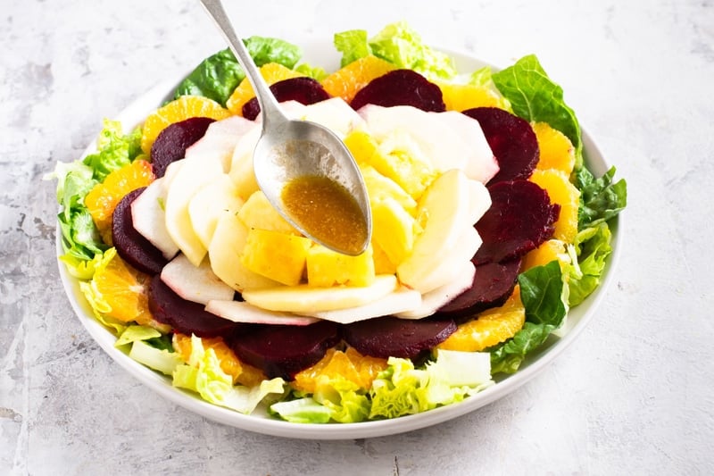 Layer the fruit, pomegranate seeds on top of a bed of lettuce