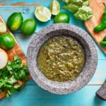 salsa verde in a molcajete on blue table.