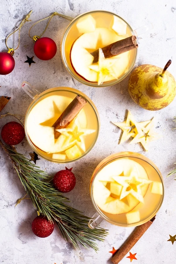 Portrait of Mexican Hot Fruit Punch - Ponche de Frutas on a white table. 