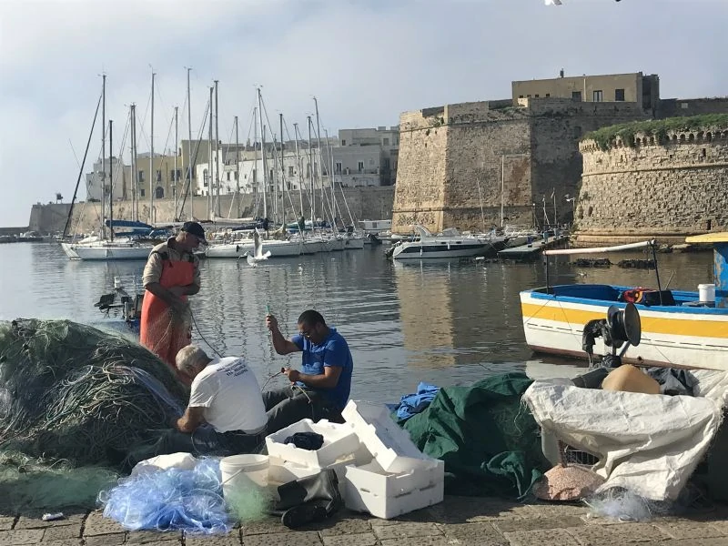 Fishermen in the harbour in Gallipoli in Puglia, Italy