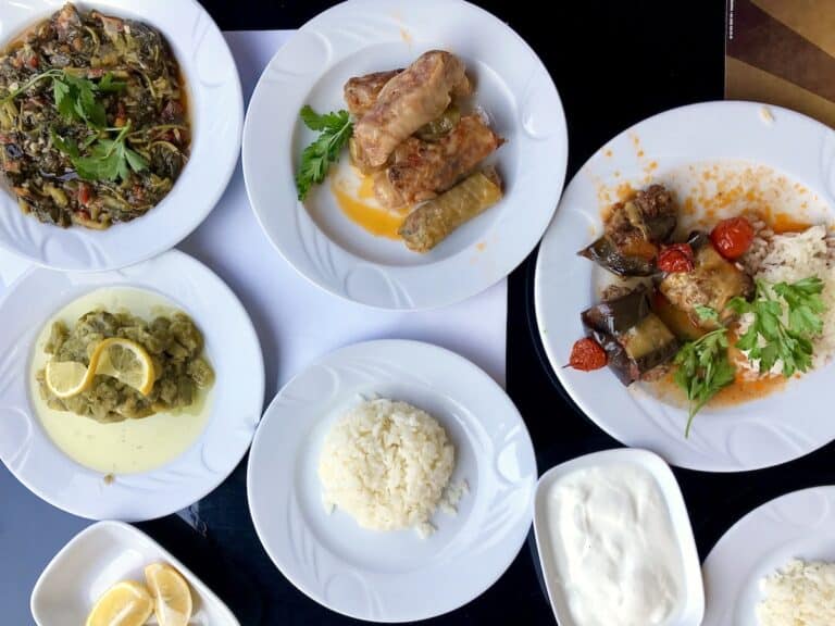 An overhead shot of traditional Turkish food and white rice on white plates in Turkey. shes