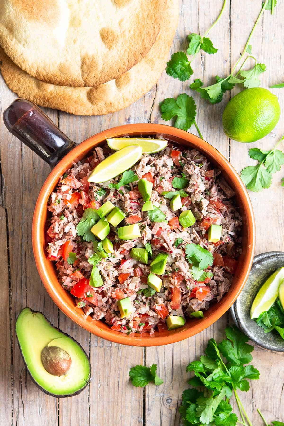 Shredded beef salad fashionable in Mexico and Guatemala proven in a bowl on a wooden table.  Salpicón: shredded beef and mint sa salpicon de res shredded beef salad 1