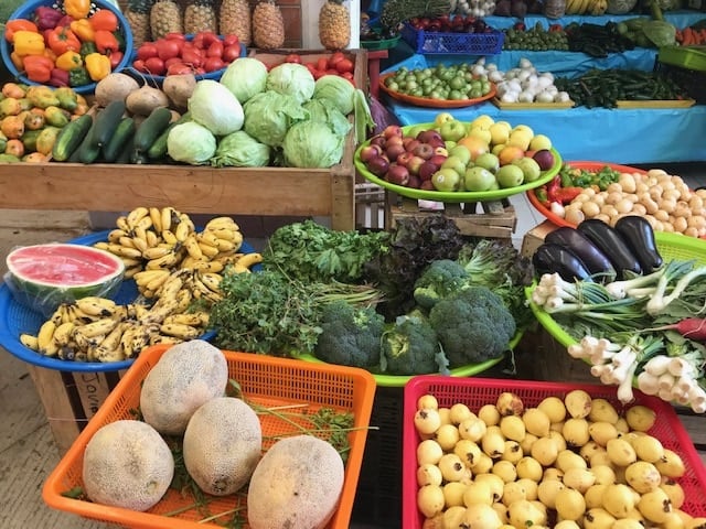 Fresh fruit and veggies in plastic bins at Zicatela Market in Puerto Escondido, Oaxaca. 