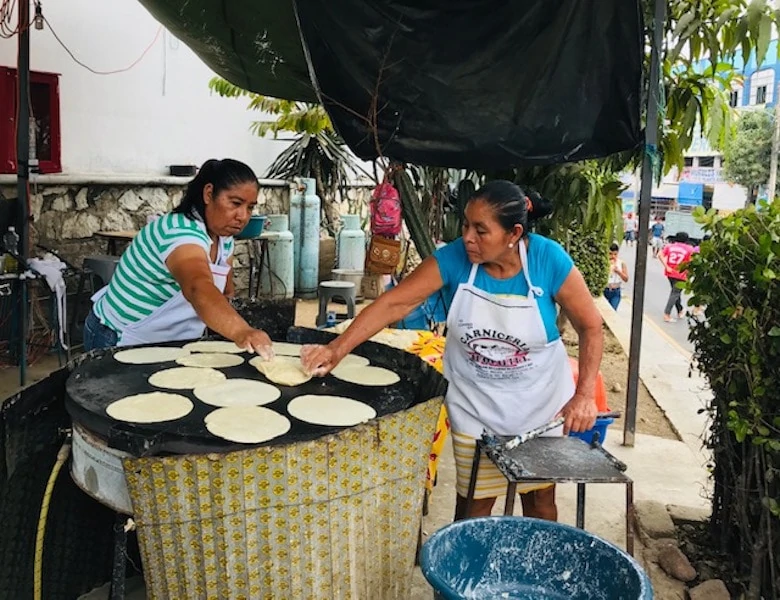 Women making tortillas de maize, a top food in Puerto Escondido Mexico.