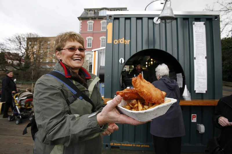 Woman holding fresh seafood at Red Fish Blue Fish.