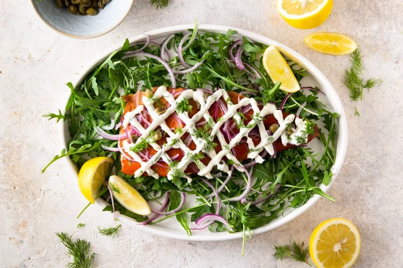 Smoked Trout Appetizer with greens on a white platter.