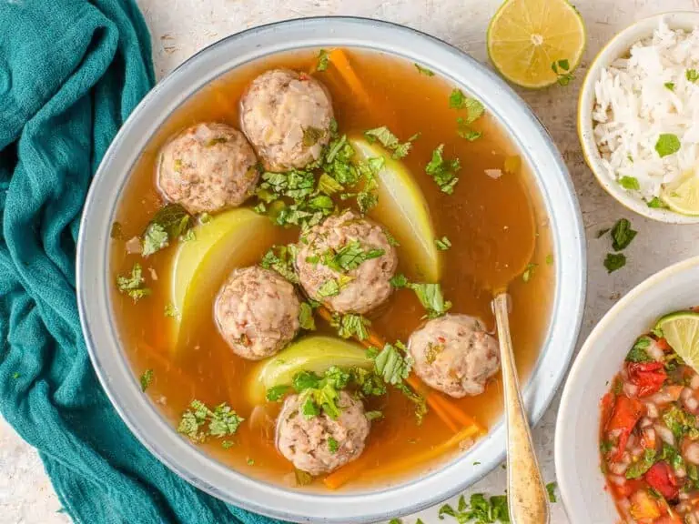 Sopa de albondigas in a bowl with a spoon.