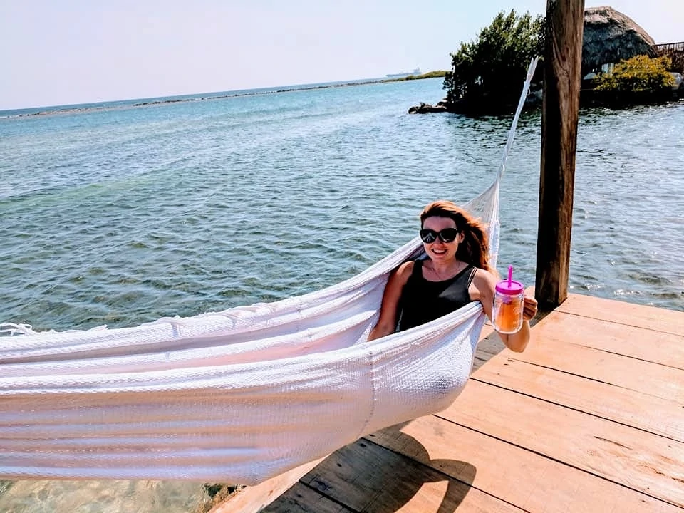 Woman in a hammock with a cocktail 