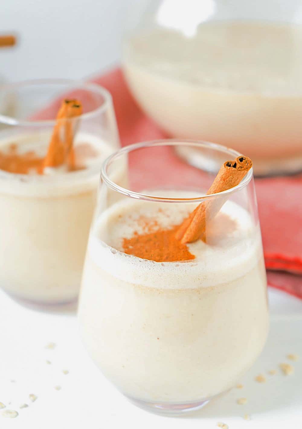 Guatemalan agua de avena in a pitcher with two glasses. 