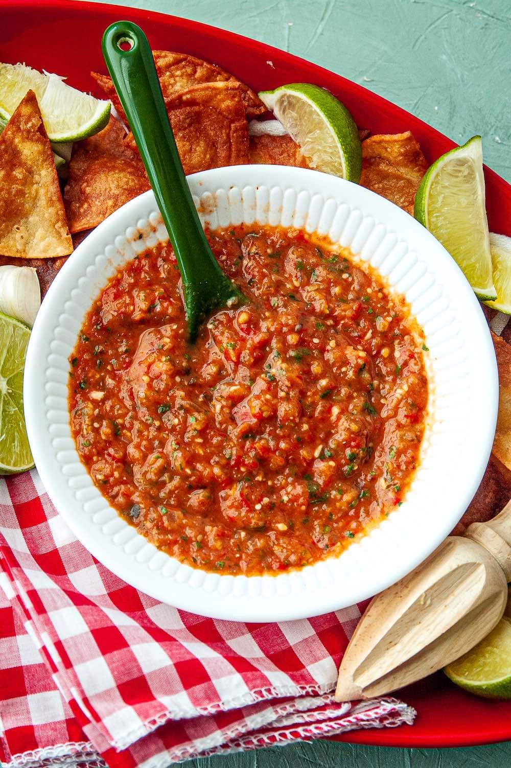 Charred tomato salsa in a bowl on a tablecloth. 