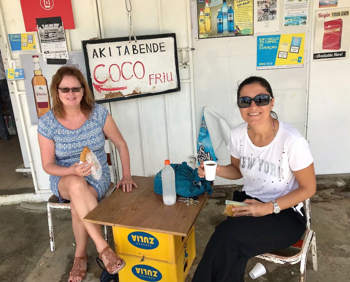 Two women eating pastechis in Curacao, Dutch Caribbean. 