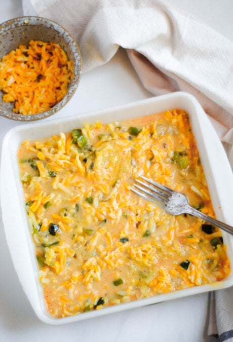 Grated cheese added to the top of a meatless egg bake in a baking dish.