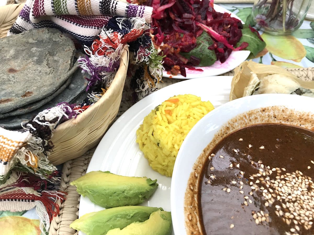 Pepian, blaue Maistortillas, Reis und Avocado auf einem Teller im Restaurant Sabe Rico in Antigua Guatemala.