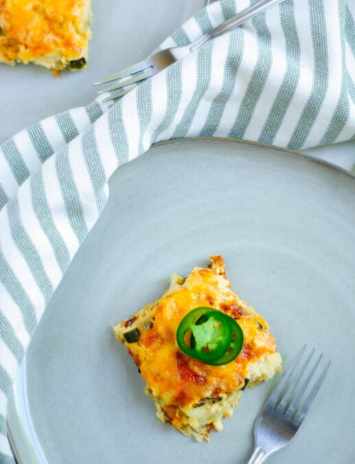 A meatless egg bake topped with avocado, served on a blue plate.
