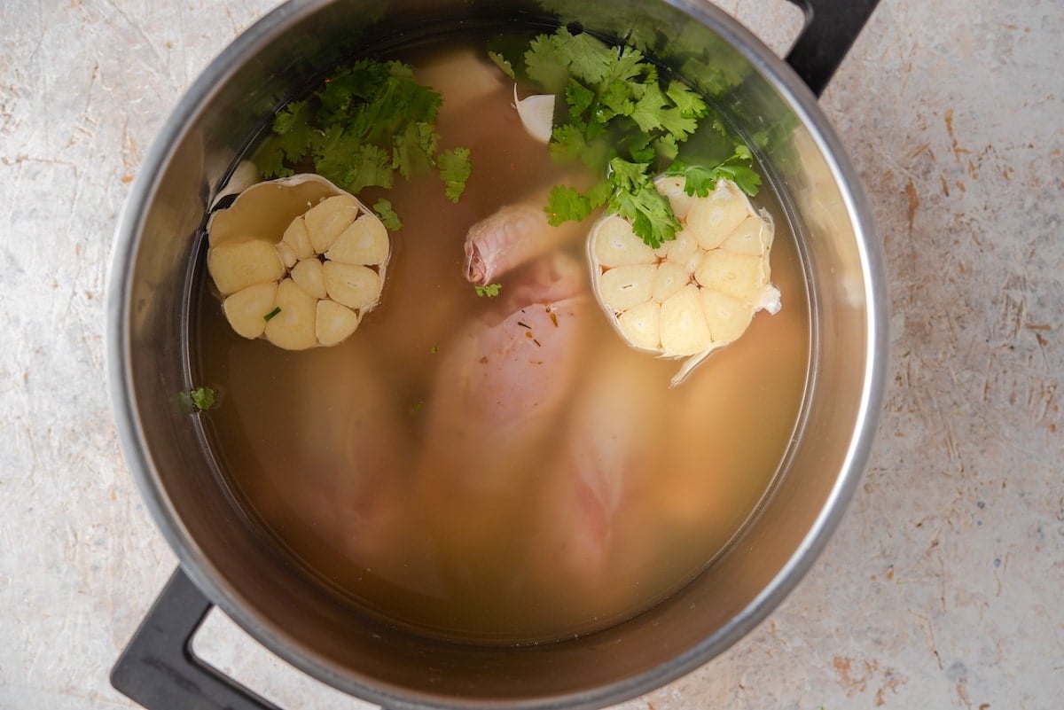 Turkey cooking in a pot with garlic and cilantro.