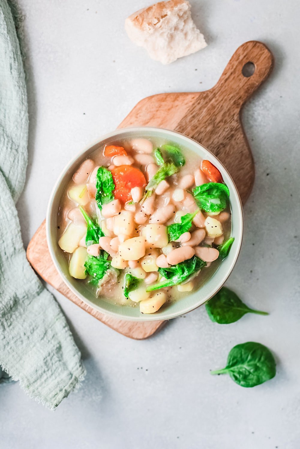 Vegetarian Caldo Gallego white bean soup in a white bowl.