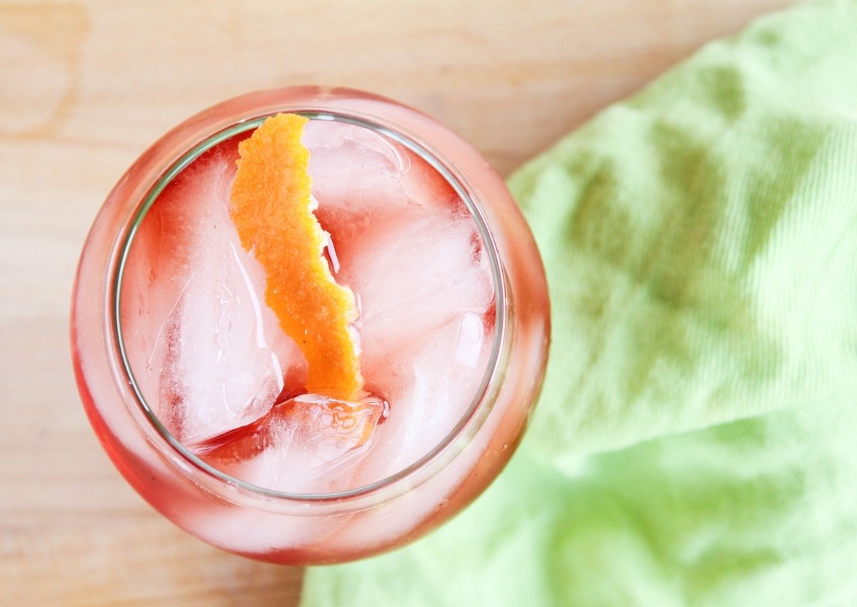 Overhead shot of a Campari cocktail with orange garnish. 