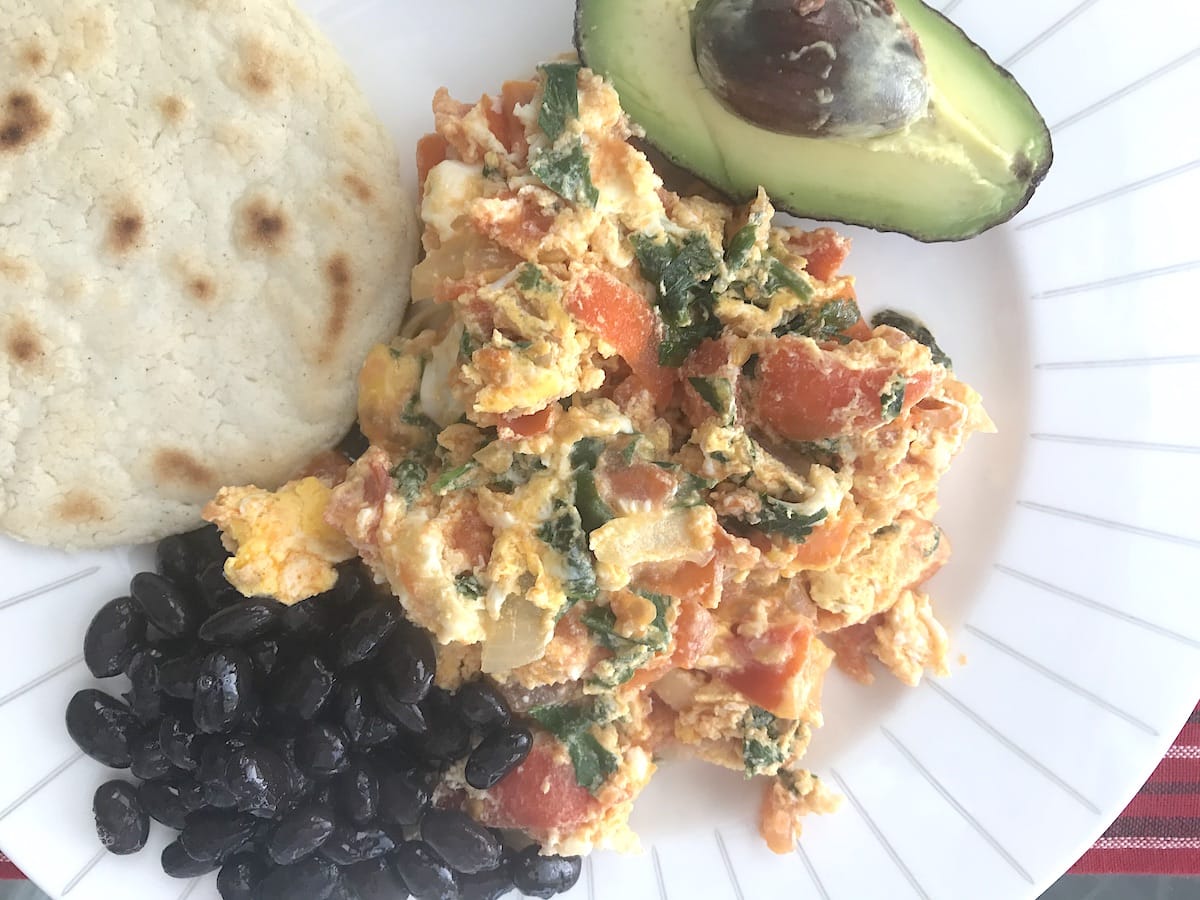Guatemalan scrambled eggs with tomato served with black beans and avocado. 