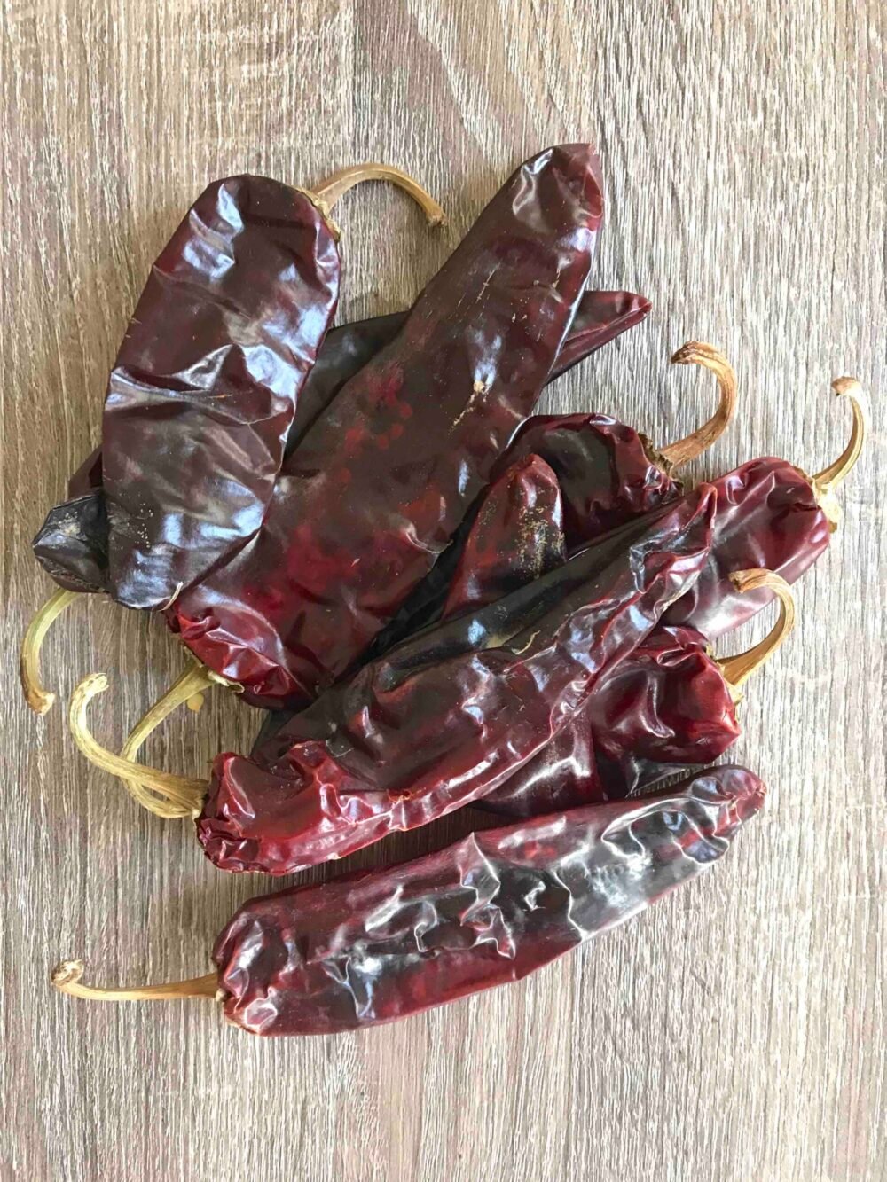 Guaque or guajillo chilis on a wooden table. 