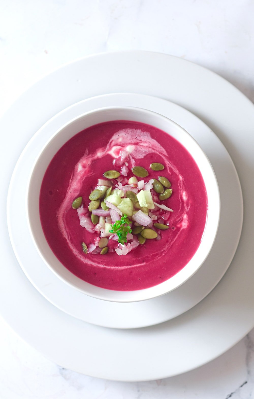 Overhead shot of gazpacho de remolacha or chilled beet soup in a white bowl. 