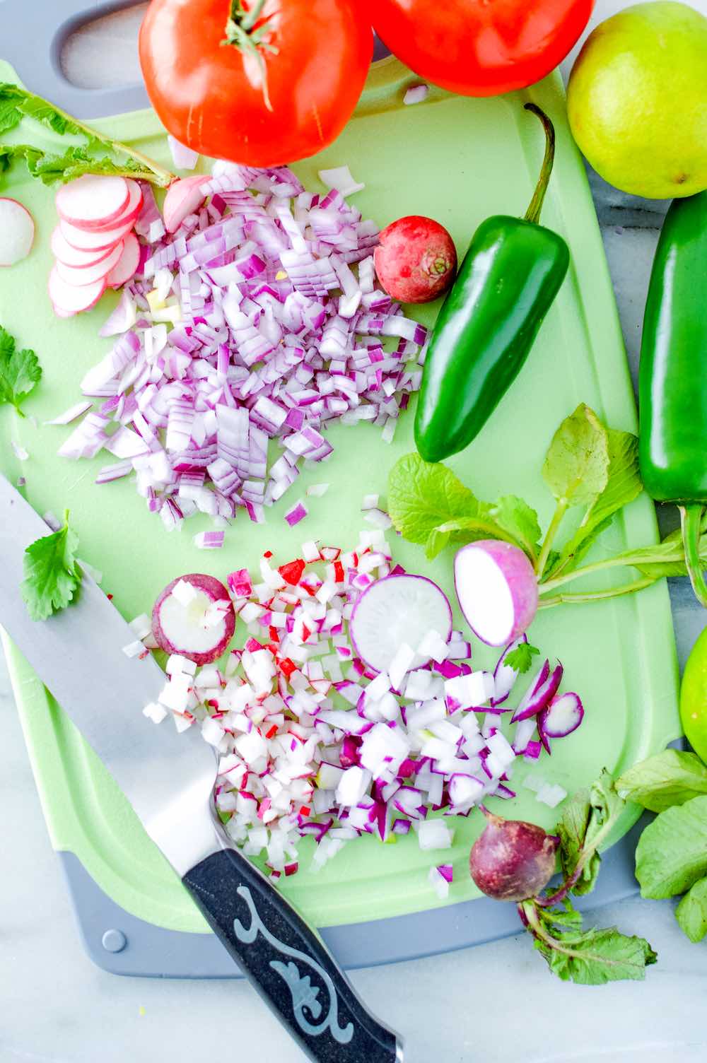 Process shot of chopping radishes and onions.