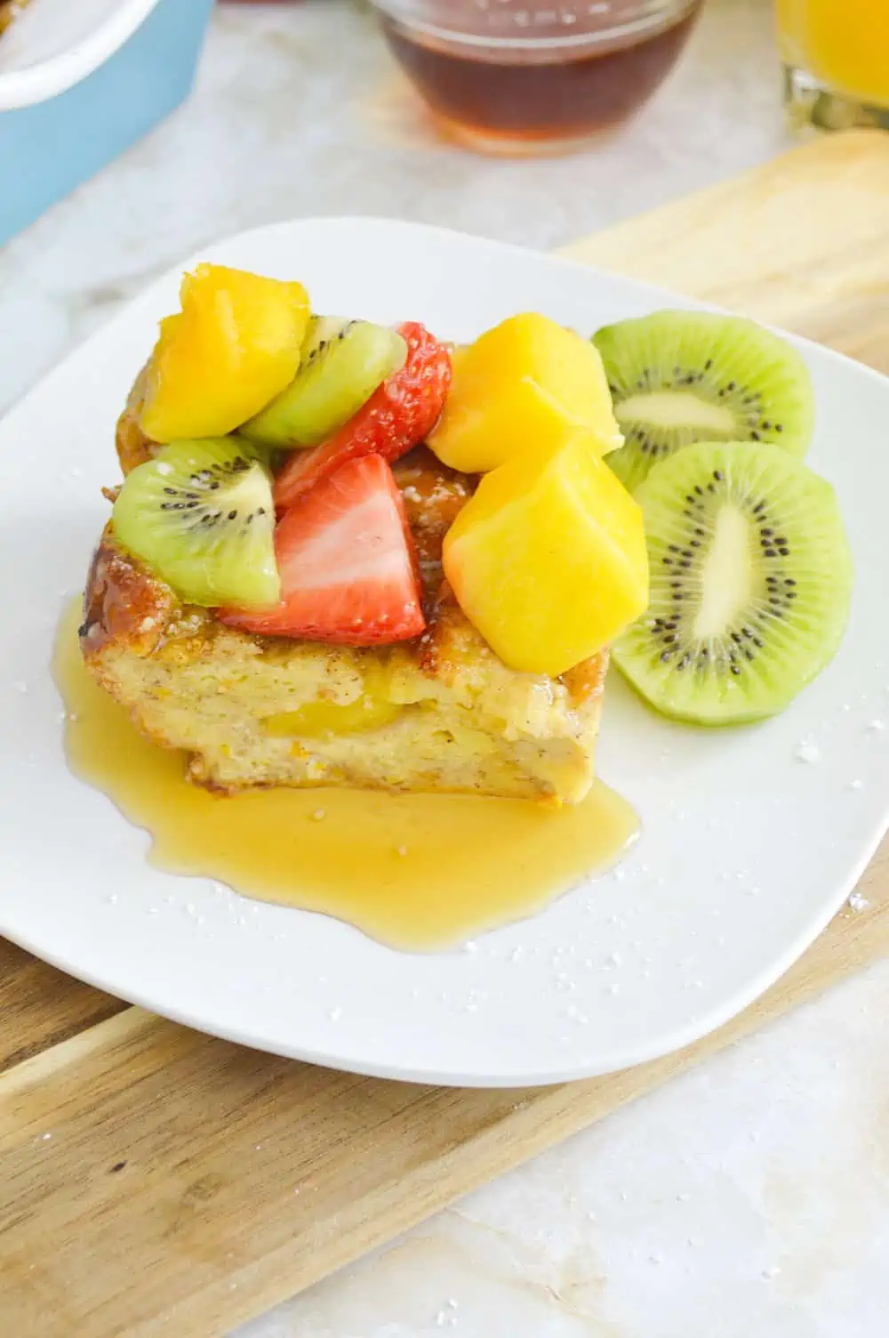 French toast casserole served with fruit and syrup. 
