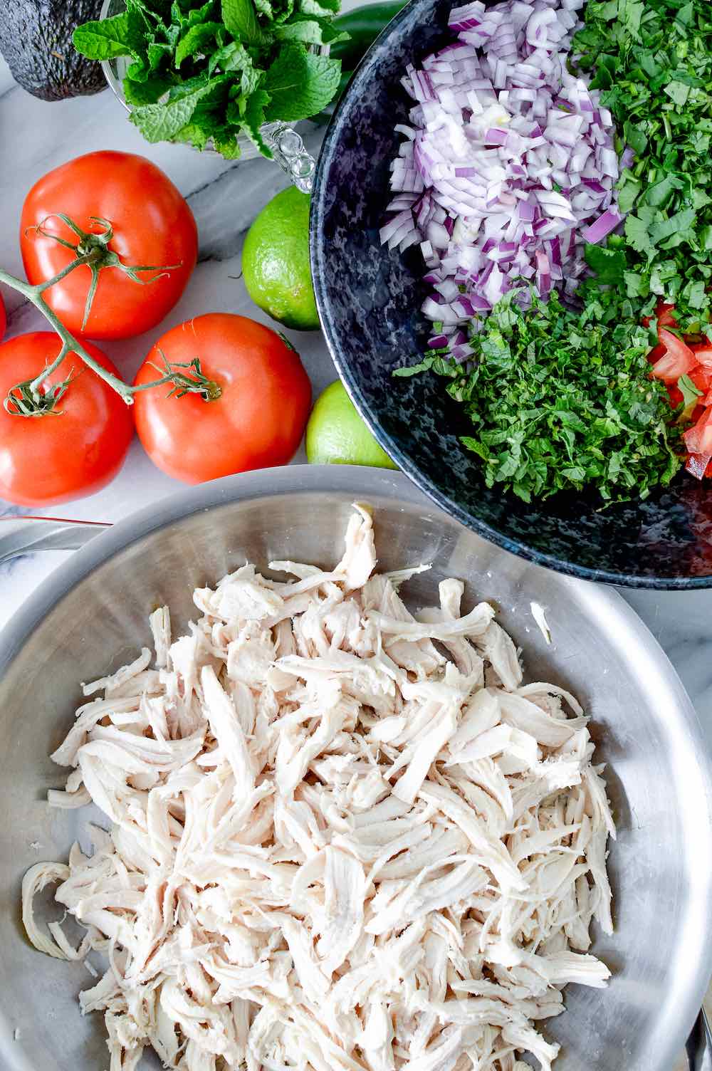 Shredded chicken in a metal bowl.