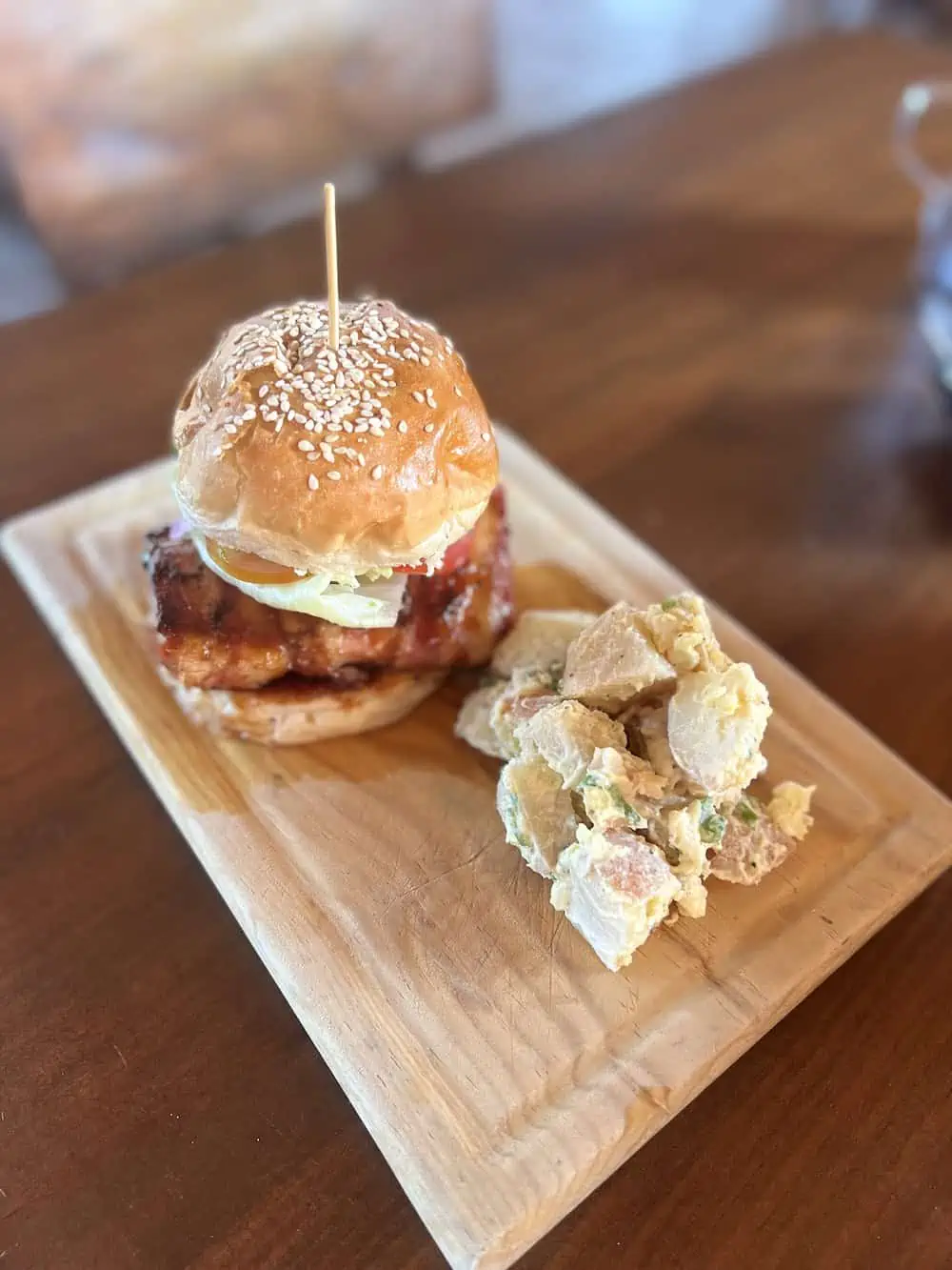 Towering fish sandwich served on a board at el nene.